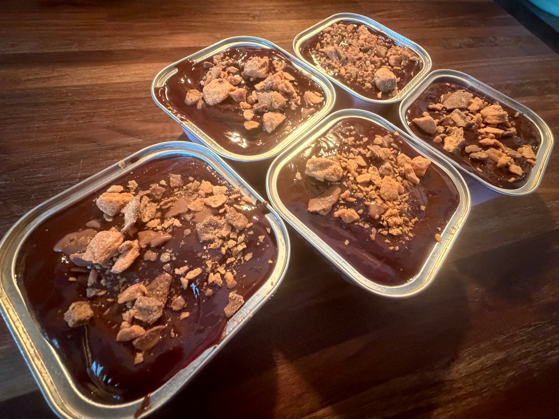 A batch of Heather's dessert tins lined up with chocolate tops and candy pieces